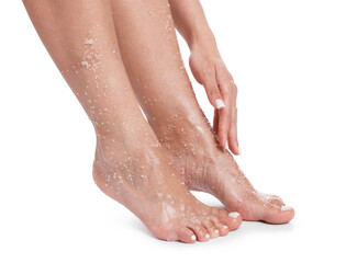 Woman applying body scrub onto her feet on white background, closeup