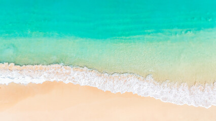 Tropical beach with turquoise water and foamy waves lapping soft white sand under sunny skies