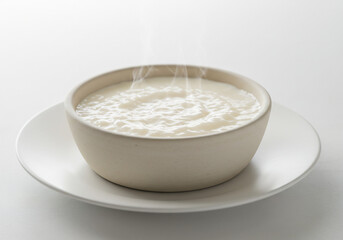Creamy Porridge in a Beige Bowl with Steam, on White Plate