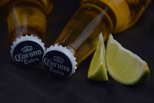 Bottles of Corona Extra Beer on dark background with ice and lime.