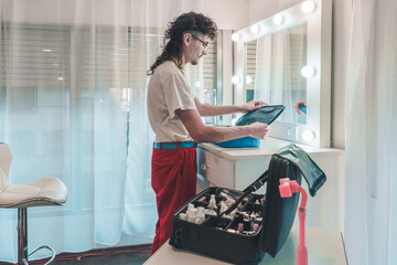 Makeup artist preparing cosmetics in dressing room with mirror and lights