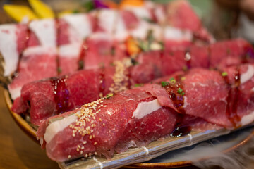 Japanese style sliced rare beef  meat on the plate with smoke and decoration, soft focus