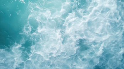 Fototapeta premium Aerial view of ocean waves creating beautiful pattern of white foam against turquoise background, evoking sense of tranquility and nature beauty