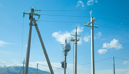 Electric cables on electric poles with a blue sky.