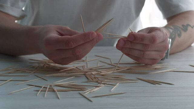 Many toothpicks in hands close-up.
Wooden sticks for oral hygiene.
Clean and fresh mouth.
Brushing teeth after eating
