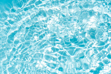 Blue water with ripples on the surface. Defocus blurred transparent blue colored clear calm water surface texture with splashes and bubbles. Water waves with shining pattern texture background.
