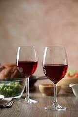 Red wine and delicious dinner served on wooden table