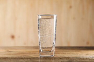 Refreshing soda water in glass on wooden table, closeup
