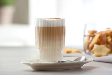 Tasty latte macchiato in glass on white table, closeup. Coffee drink