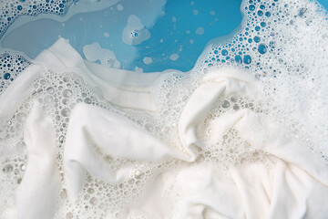 White clothes soaked in water before washing, top view
