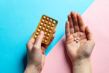 Woman with contraceptive pills on color background, closeup