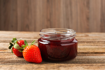 Delicious strawberry sauce and fresh berries on wooden table, closeup. Space for text