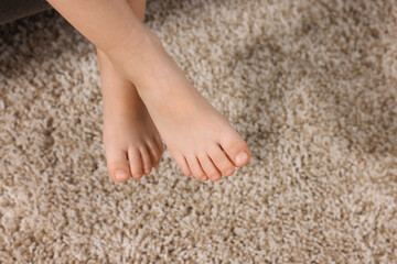 Little child above soft beige carpet indoors, closeup. Space for text