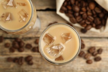 Coffee cream liqueur in glasses and beans on table, flat lay