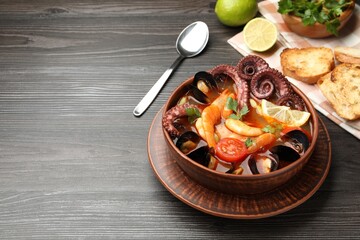 Tasty seafood soup served on wooden table. Space for text