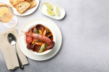 Tasty seafood soup served on light grey table, flat lay. Space for text