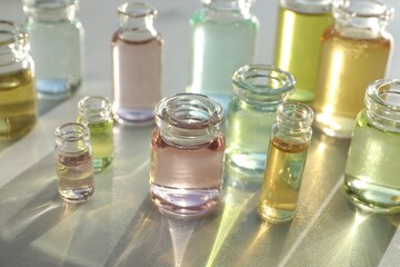 Perfume bottles with aromatic oils on light background, closeup