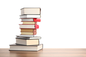 Stack of old books on wooden table against white background