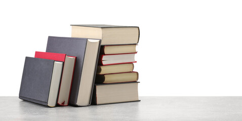 Old books on light grey table against white background