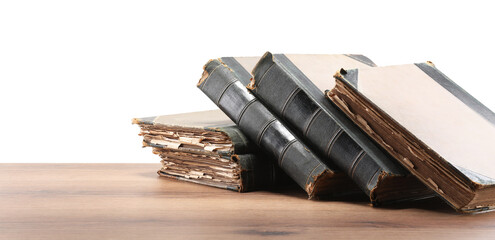Old books on wooden table against white background