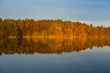 Sunrise over a tranquil lake near Gothenburg highlights nature's beauty and reflections