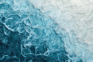 Fototapeta premium A close-up of two-colored sea water, where light blue water with gentle waves transitions into a darker blue hue, forming a natural gradient. The sunlight reflects off the surface