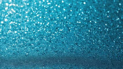 Obraz premium Closer view of blue glittering particles scattered on surface.