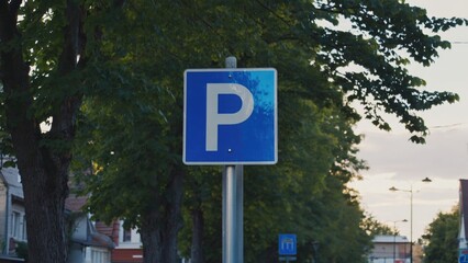 Fototapeta premium Blue parking sign indicating a designated parking space in an urban area.