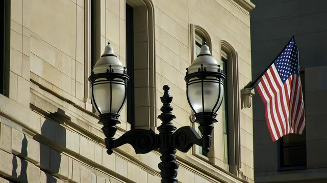 Historic building exterior with American flag and vintage street lamps during daylight hours