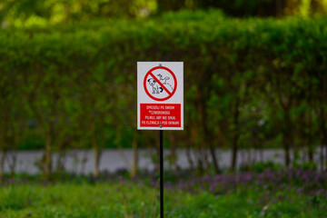 Znak zakazu wyprowadzania ps&oacute;w na trawniku w parku