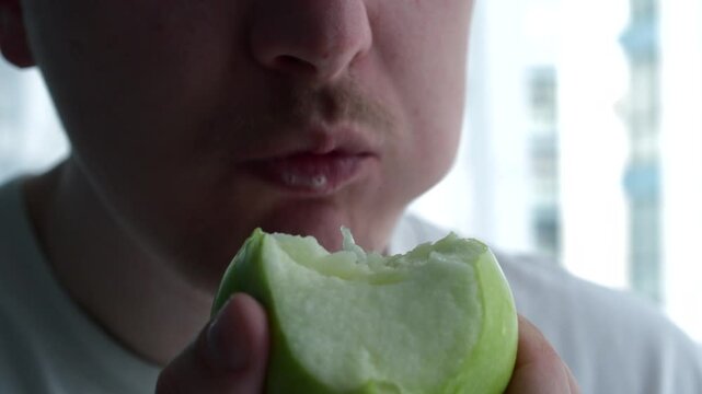 A man bites a green apple.
A man eats a ripe and juicy apple.
Apple, bite, eat, food, vitamins