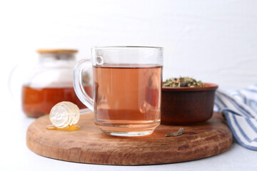 Delicious herbal tea, honey and dry leaves on white table
