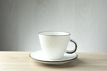 Empty cup and saucer on wooden table