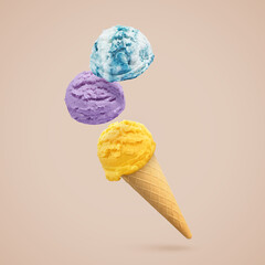 Ice cream scoops and waffle cone in air on dark beige background