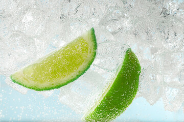 Soda water with lime slices and ice cubes, closeup