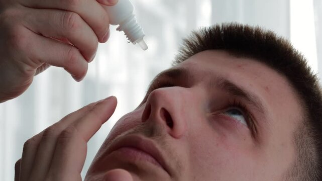 A man uses eye drops.
Eye drops close-up.
A man puts special drops in his eyes for vision