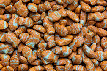 Fish Shaped Dry Pet Food with white stripes. Close-Up of Colorful Fish-Shaped. Dry Cat or Dog Food Background
