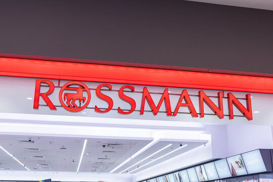 Poznan, Poland - March 15, 2025: Rossmann store entrance with illuminated red logo and modern interior lighting inside shopping mall, showcasing popular drugstore and beauty chain