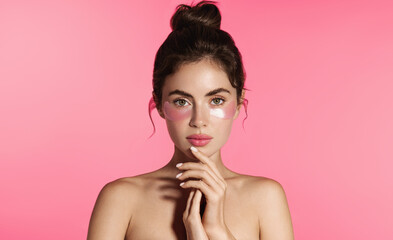 Radiant young woman with glowing skin, full lips, and thick brows poses with hydrating under-eye...