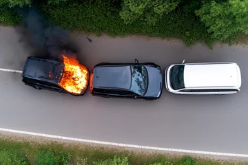 Battlefield view shows multiple burning vehicles amidst destruction and chaos in a conflict area