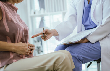 A female doctor is examining a woman's history of abdominal pain.