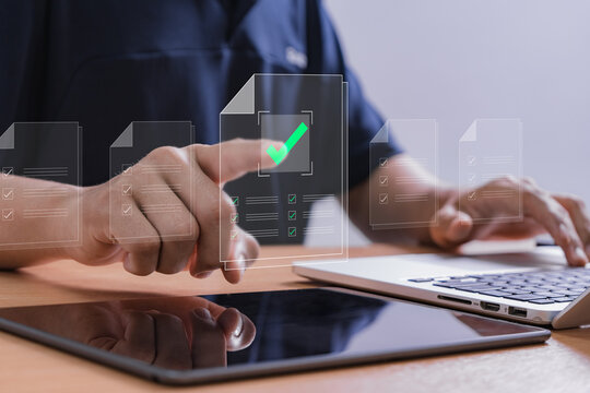 User interacting with digital document approval checklist on touchscreen interface, representing paperless workflow, task verification, and smart business automation through laptop and tablet devices