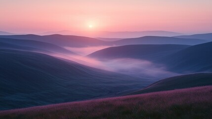 Obraz premium Mountain vista with rising sun through fog, and grassland in the foreground
