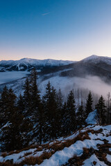 Winter hiking to Sina in Low Tatras National park near jasna is full of beautiful views. Sunset in Slovakia mountains with Chopok peak.