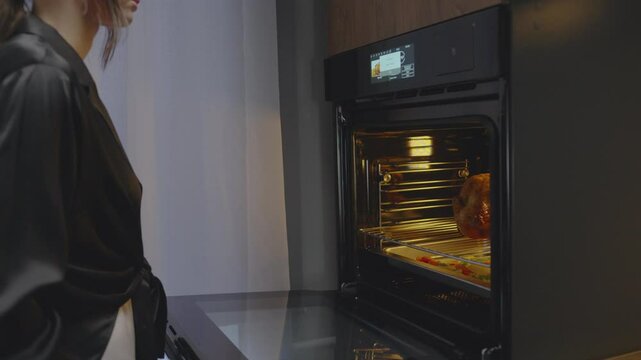 oven. woman putting food in oven. technology. woman's hands closing oven