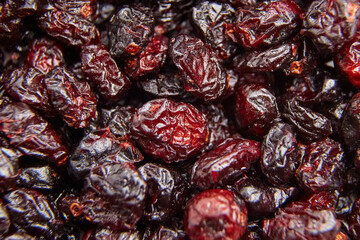 Macro shot of dried cranberries featuring deep red hues, wrinkled textures, and glossy surfaces, perfect for food and snack-related visuals