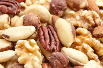 A detailed close-up of assorted mixed nuts, including pecans, Brazil nuts, hazelnuts, cashews, almonds, and walnuts, highlighting natural textures and variety