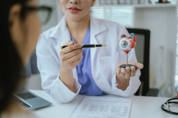 Surgeon with human eye model and explains modern clinical treatment