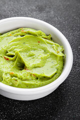 Guacamole dip avocado sauce cold appetizer vegetables dish organic fresh tasty gourmet food background on the table rustic food top view copy space keto and paleo diet vegetarian and vegan food