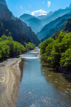 Scenic viewpoint from the historic Konitsa stone bridge into the Aoos River gorge, part of Vikos&ndash;Aoos National Park, Epirus, Greece. Majestic mountains, cliffs, and lush forest scenery.